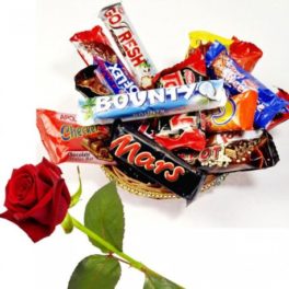 Cestino con dolciumi misti al cioccolato e rosa rossa