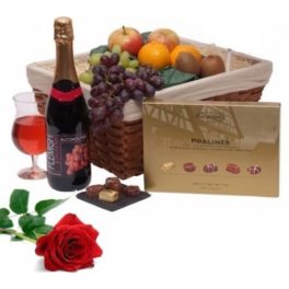 cesto gastronomico da regalo con frutta vino rosso e una rosa rossa